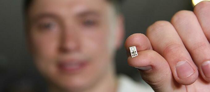 person holding a very small computer chip