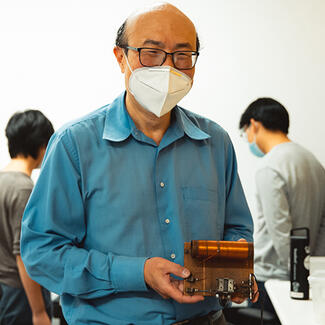 Prof Tom Lee with an AM radio he made in elementary school. Photo credit Andrew Brodhead